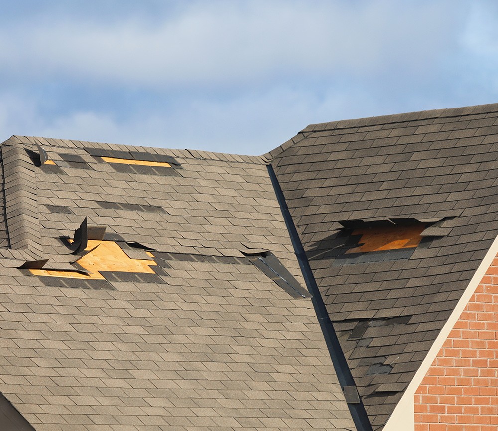 Roof with missing shingles after wind storm